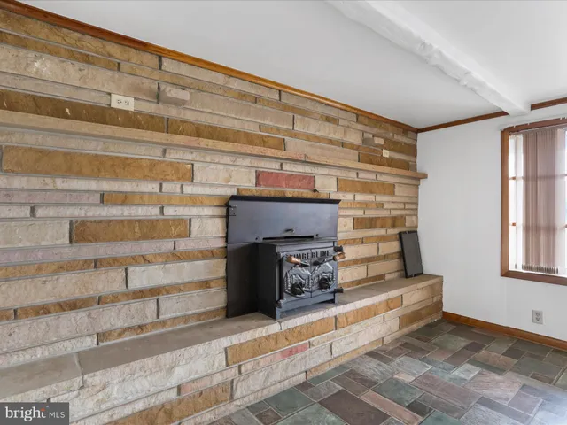 a view of fireplace and window in an empty room