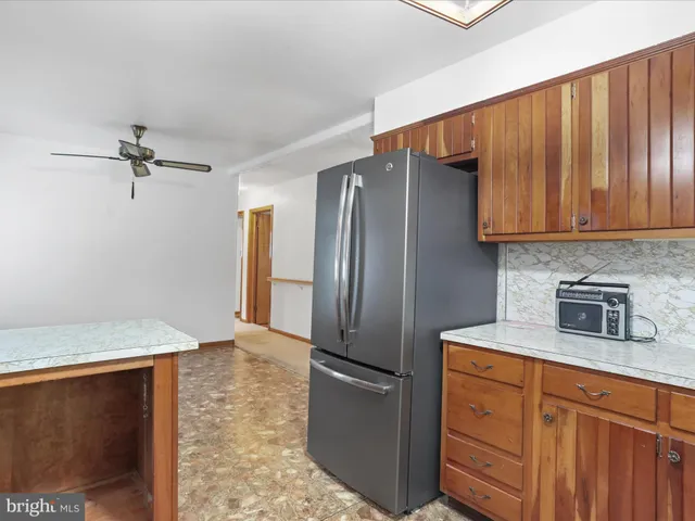 a kitchen with stainless steel appliances granite countertop a refrigerator a stove and a sink with wooden cabinets
