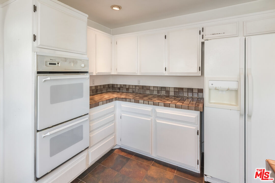 25 Hurricane Street, Unit 3 Marina del Rey, CA 90292 - Photo 19 of 27 a kitchen with white cabinets and white appliances
