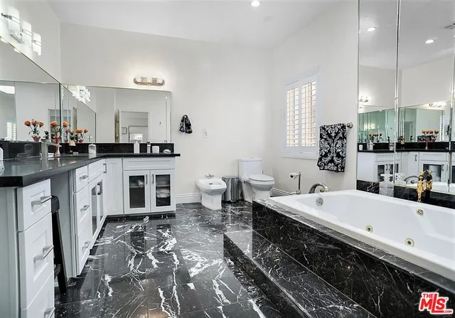 a large white kitchen with a sink and cabinets