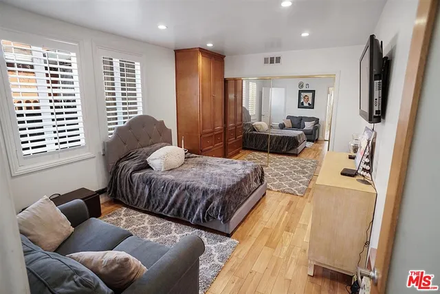 a spacious bedroom with a bed window and couch