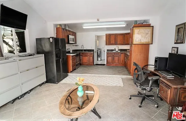 a kitchen with stainless steel appliances kitchen island granite countertop a refrigerator stove and sink