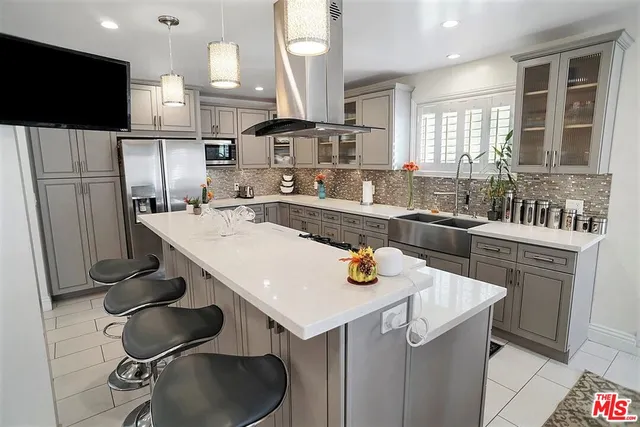 a kitchen with stainless steel appliances granite countertop a sink a stove and a refrigerator