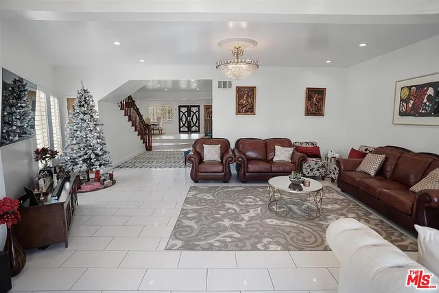 a living room with furniture flowerpot and a chandelier