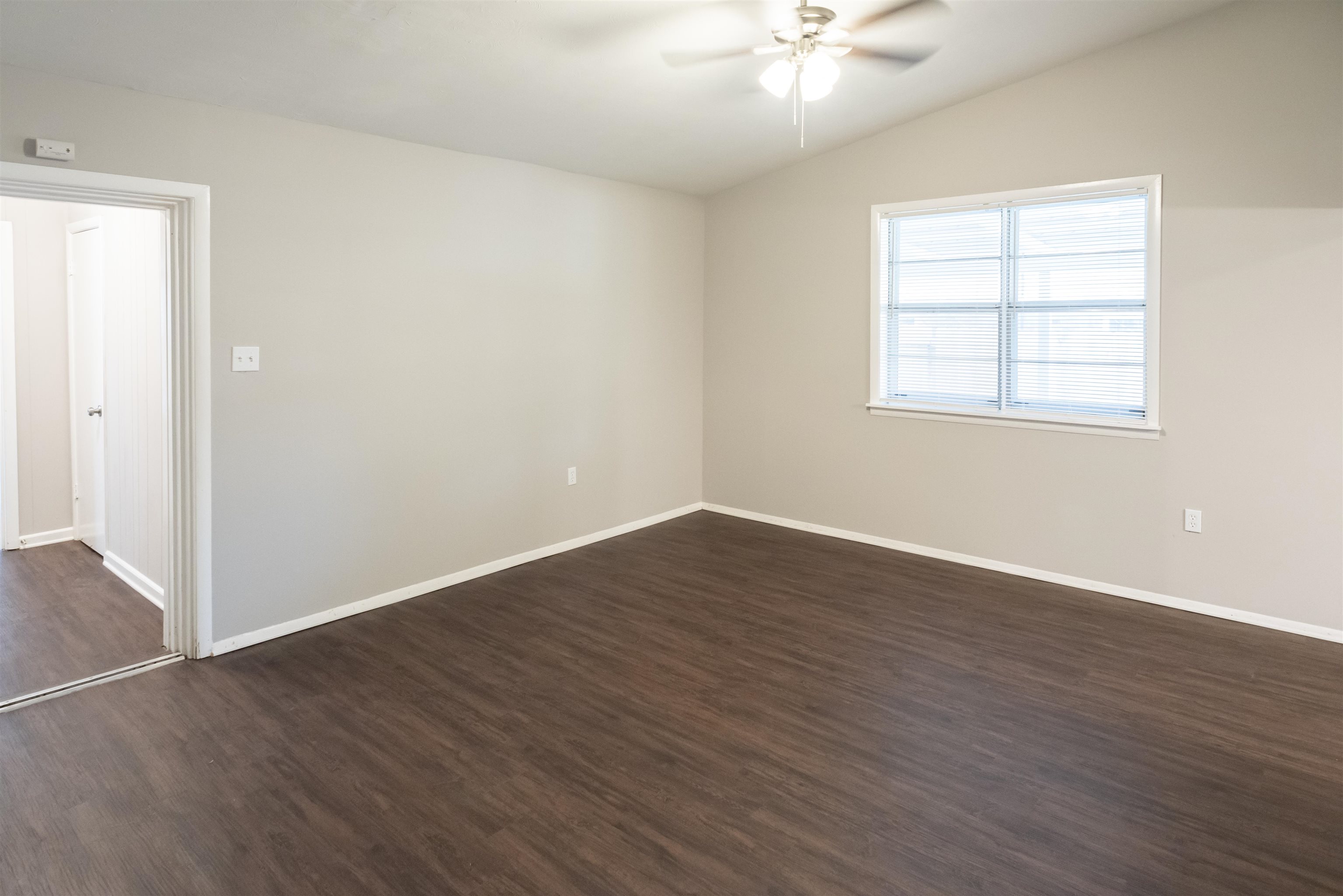 4622 Applegate Road Memphis, TN 38109 - Photo 6 of 13 an empty room with wooden floor chandelier fan and windows