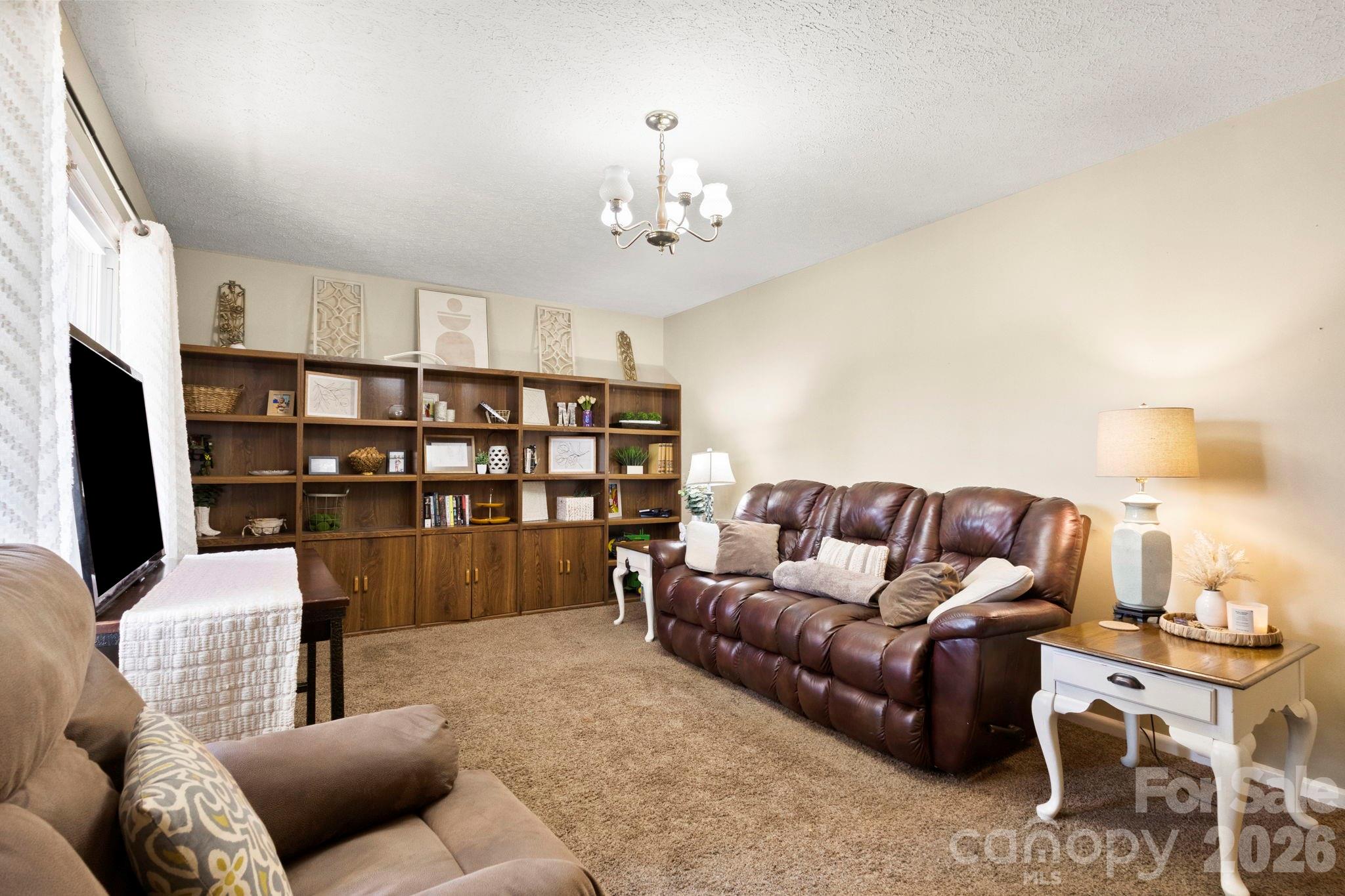 2200 Gaffney Road Shelby, NC 28152 - Photo 11 of 46 a living room with furniture a chandelier and a flat screen tv
