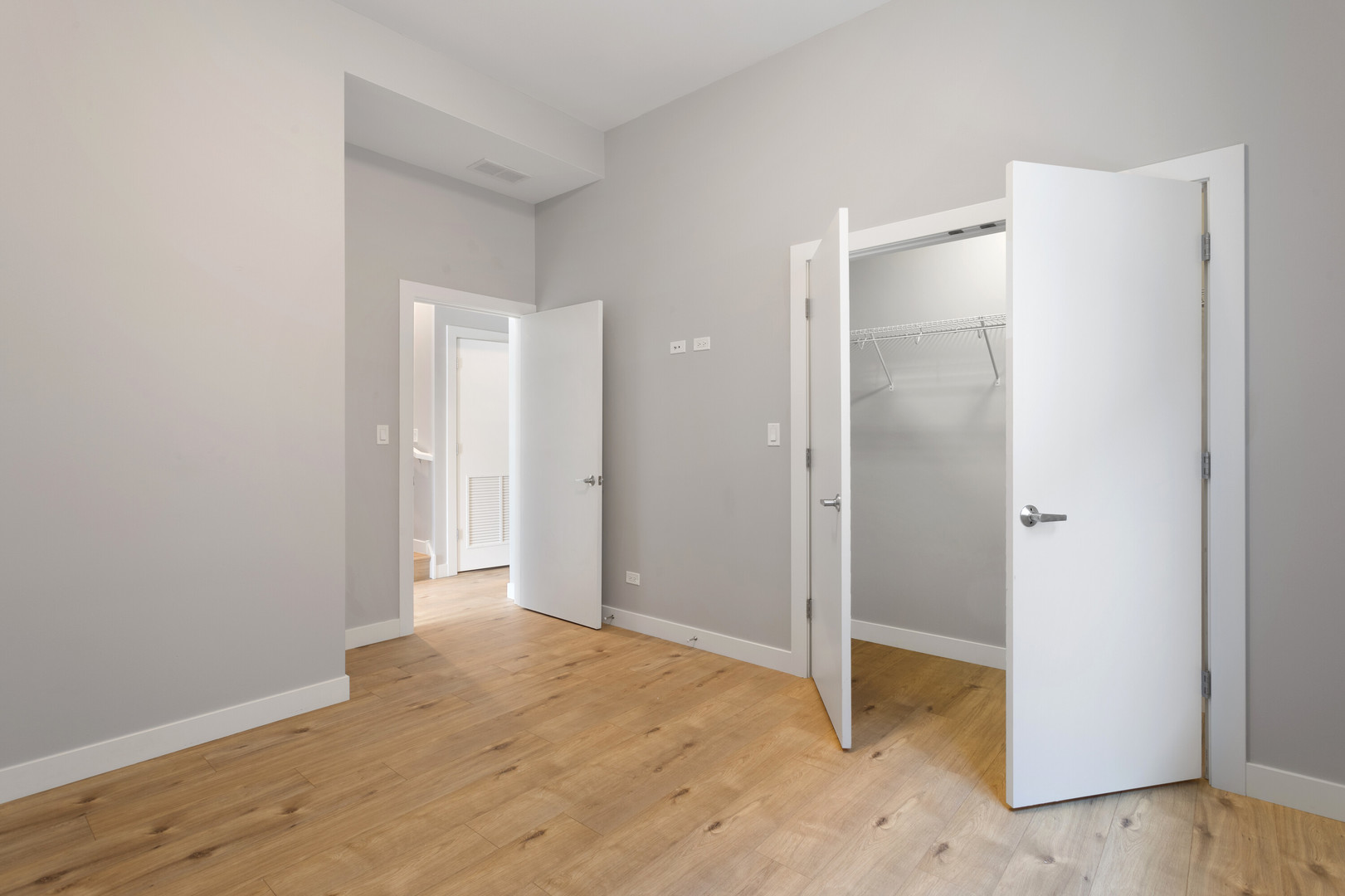 2532 West Addison Street, Unit 2E Chicago, IL 60618 - Photo 13 of 17 a view of an empty room with wooden floor and a bathroom