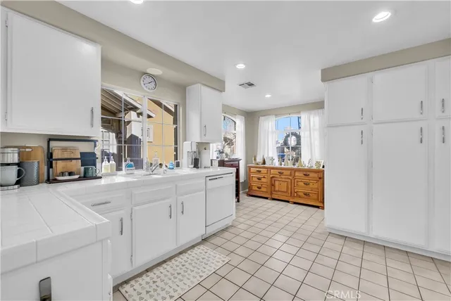 a large white kitchen with cabinets and a wooden floor