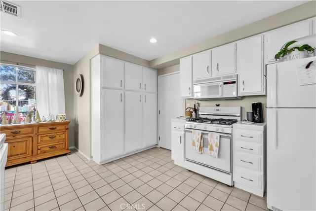 a kitchen with cabinets stainless steel appliances and a window
