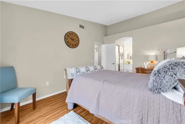 a bedroom with a bed and wooden floor