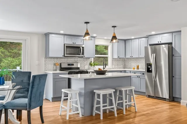 a kitchen with kitchen island granite countertop a center island a sink cabinets and stainless steel appliances
