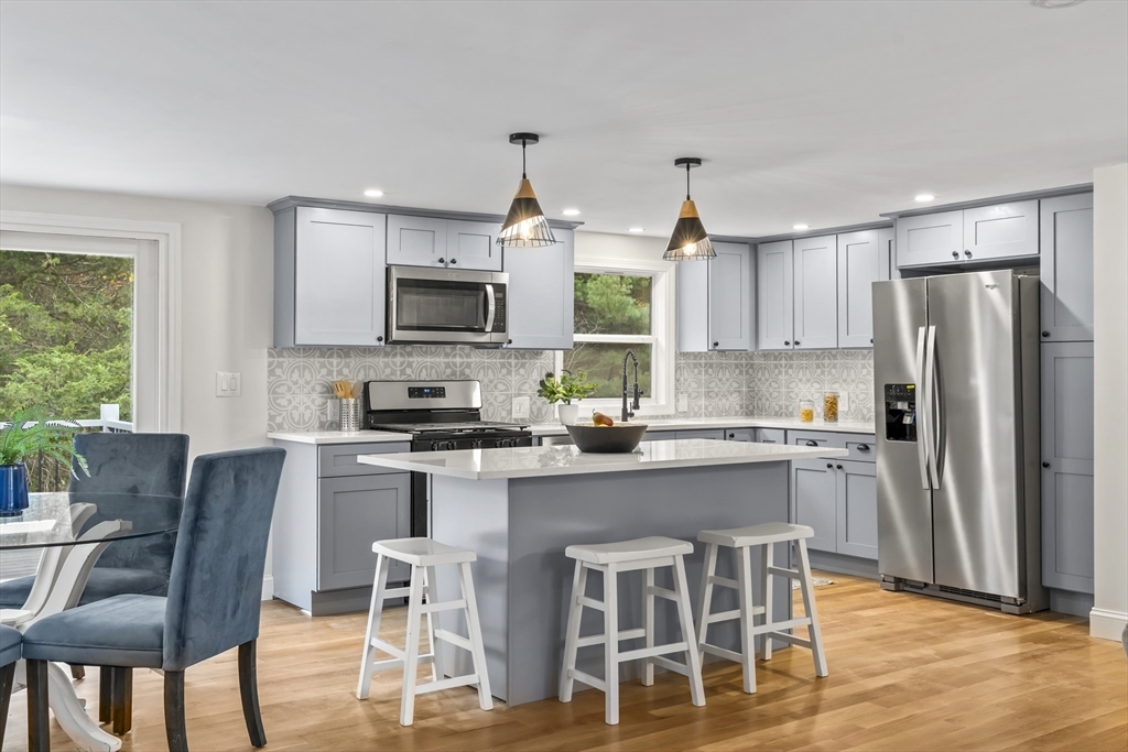 a kitchen with kitchen island granite countertop a center island a sink cabinets and stainless steel appliances