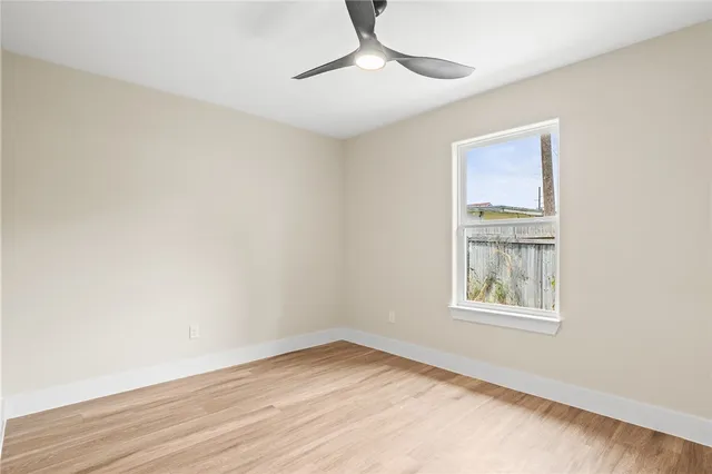 an empty room with a window and wooden floor