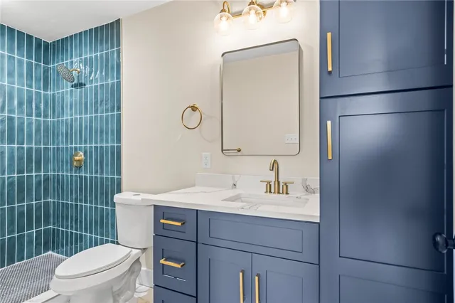a bathroom with a toilet sink vanity and mirror