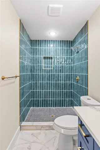 a bathroom with a sink a toilet and shower