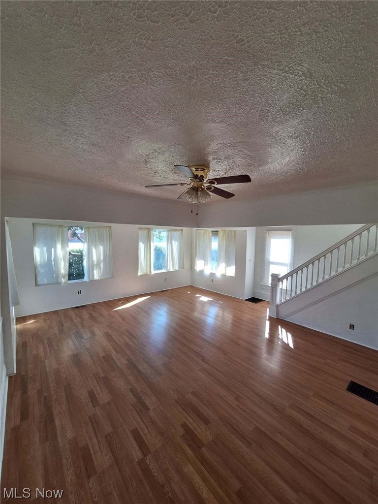 841 West Wilbeth Road Akron, OH 44314 - Photo 7 of 17 Hardwood floored empty room featuring ceiling fan and a textured ceiling