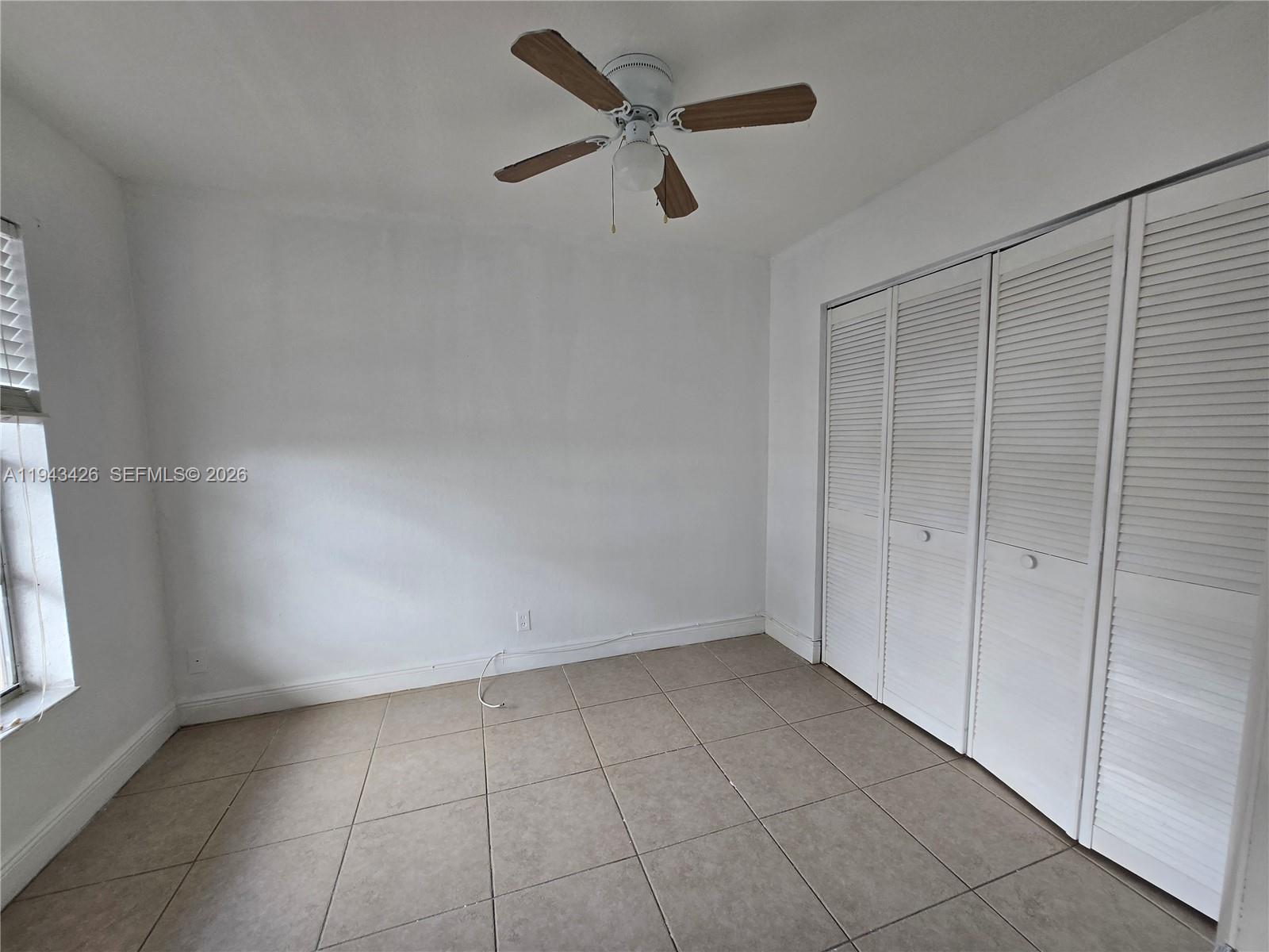 12850 Southwest 43rd Drive, Unit 250B Miami, FL 33175 - Photo 7 of 12 wooden floor in an empty room with a window