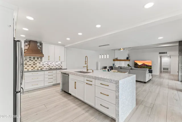 a kitchen with white cabinets and sink