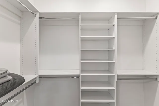 a view of walk in closet with empty racks