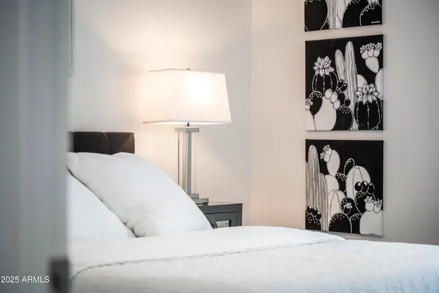 a bedroom with a bed and a painting on the wall