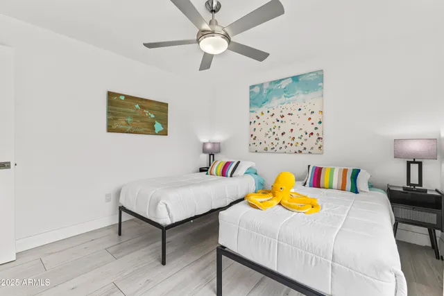 a bedroom with a bed lamps and a wall painting