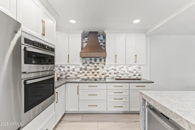 a kitchen with granite countertop white cabinets and white appliances