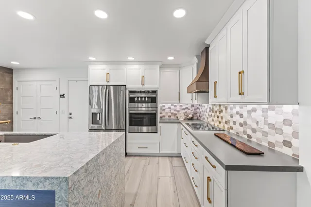 a large kitchen with stainless steel appliances granite countertop a sink and a stove