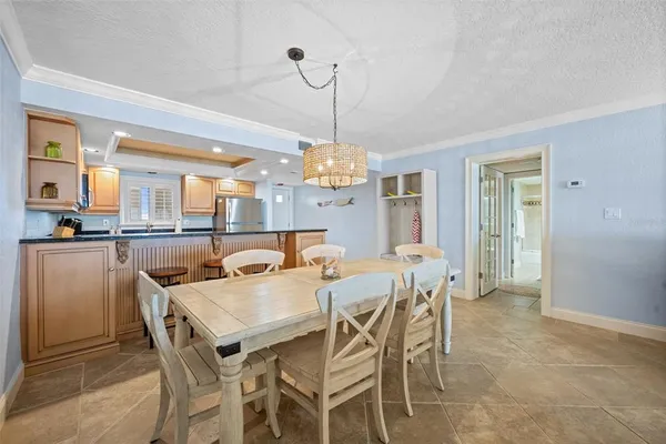 a dining room with granite countertop a table chairs and a chandelier