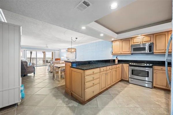 a kitchen with stainless steel appliances granite countertop a stove a sink and a microwave