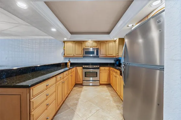 a kitchen with granite countertop a refrigerator and a sink