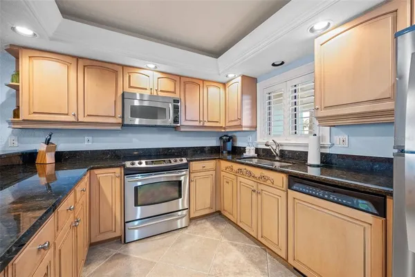 a kitchen with stainless steel appliances granite countertop a stove a sink and a microwave