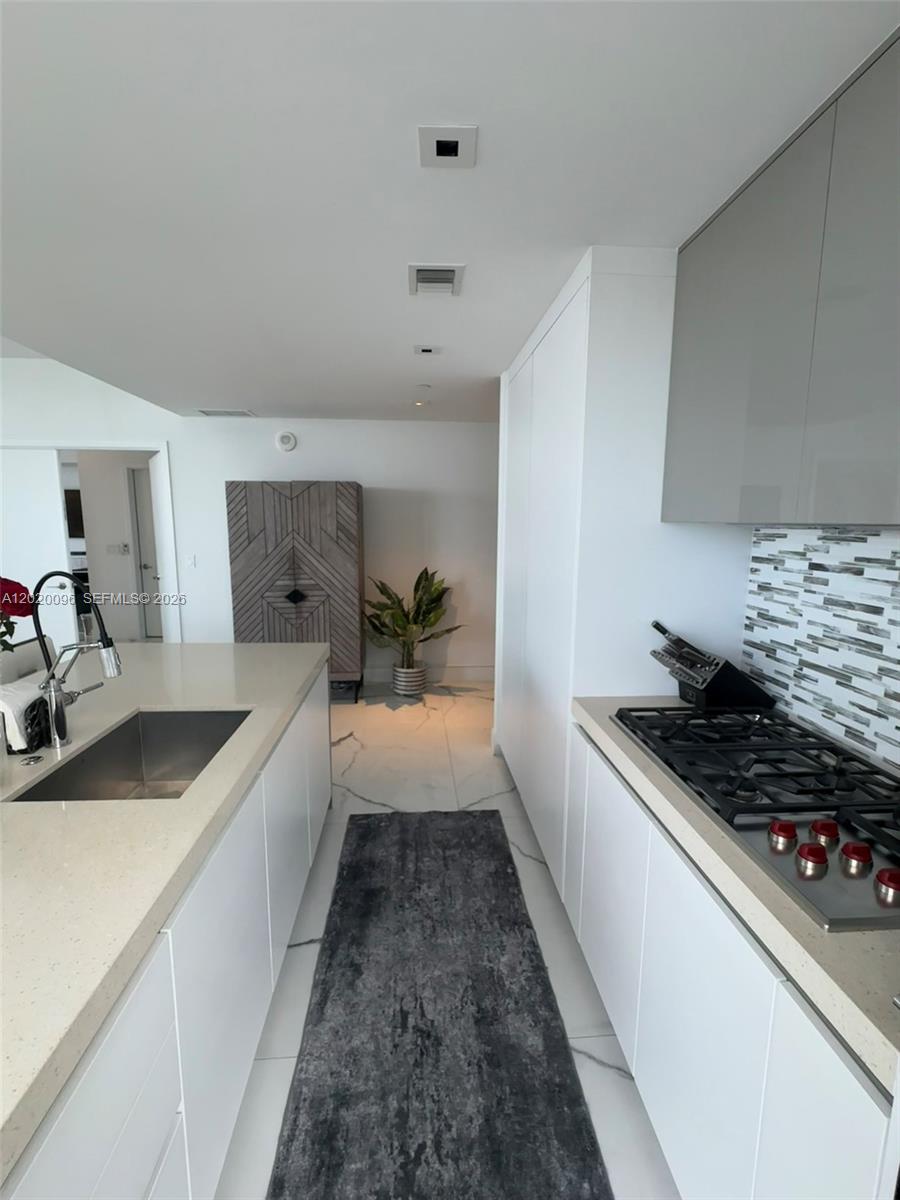 788 Northeast 23rd Street, Unit 1202 Miami, FL 33137 - Photo 14 of 64 a kitchen with granite countertop a sink stove and cabinets