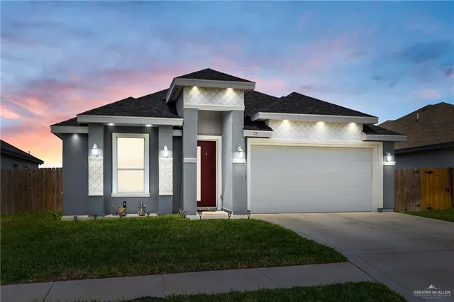 a front view of a house with a garden and yard