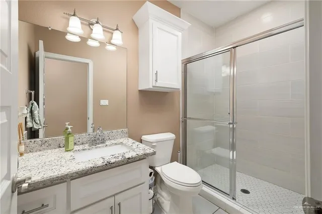a bathroom with a granite countertop sink toilet and shower