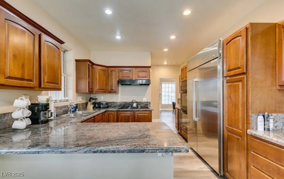 6520 Turtle Hill Road Las Vegas, NV 89110 - Photo 18 of 59 Kitchen featuring brown cabinets, built in refrigerator, recessed lighting, light wood finished floors, and a peninsula