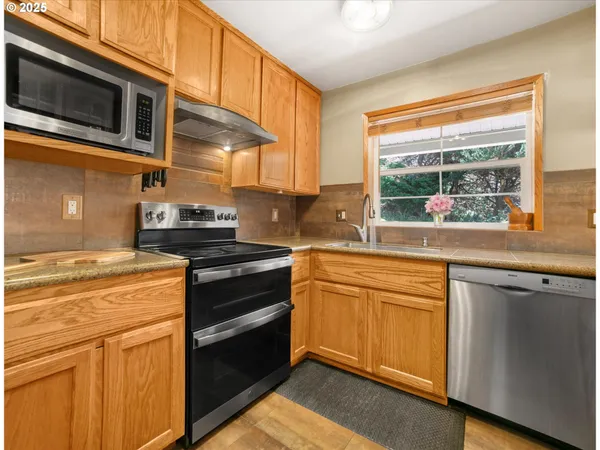 a kitchen with stainless steel appliances granite countertop a stove and a microwave
