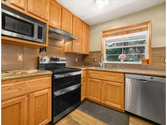 a kitchen with stainless steel appliances granite countertop a stove and a microwave