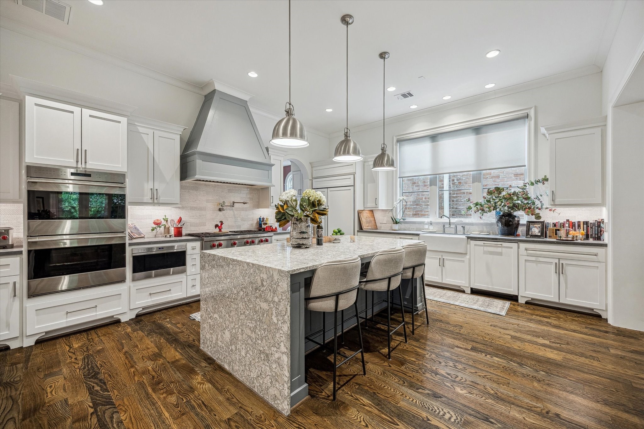2501 Yupon Street Houston, TX 77006 - Photo 12 of 48 a kitchen with stainless steel appliances a stove a sink and white cabinets with wooden floor