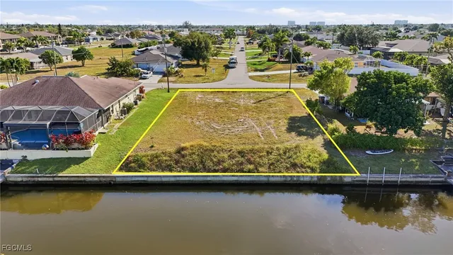 an aerial view of residential houses with outdoor space and lake view