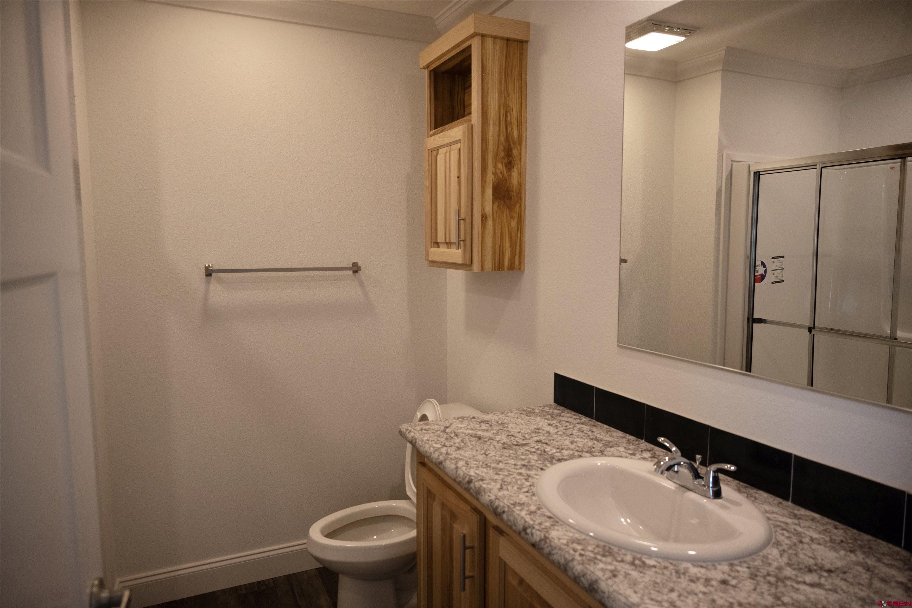 6000 County Road 203, Unit 44 Durango, CO 81301 - Photo 12 of 21 a bathroom with a granite countertop sink toilet and mirror