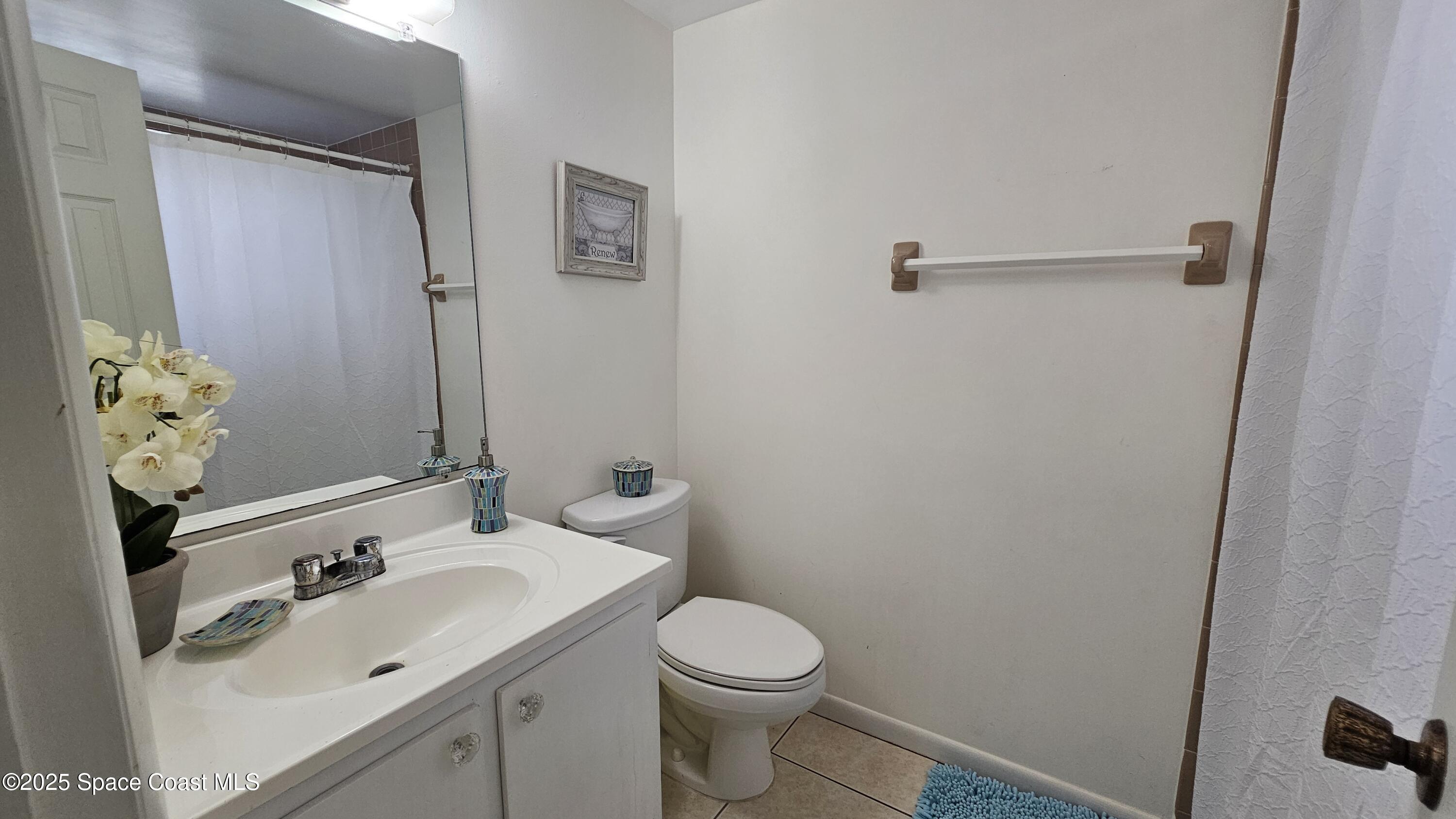 1641 Sunny Brook Lane, Unit C201 Palm Bay, FL 32905 - Photo 11 of 19 a bathroom with a sink and mirror with toilet
