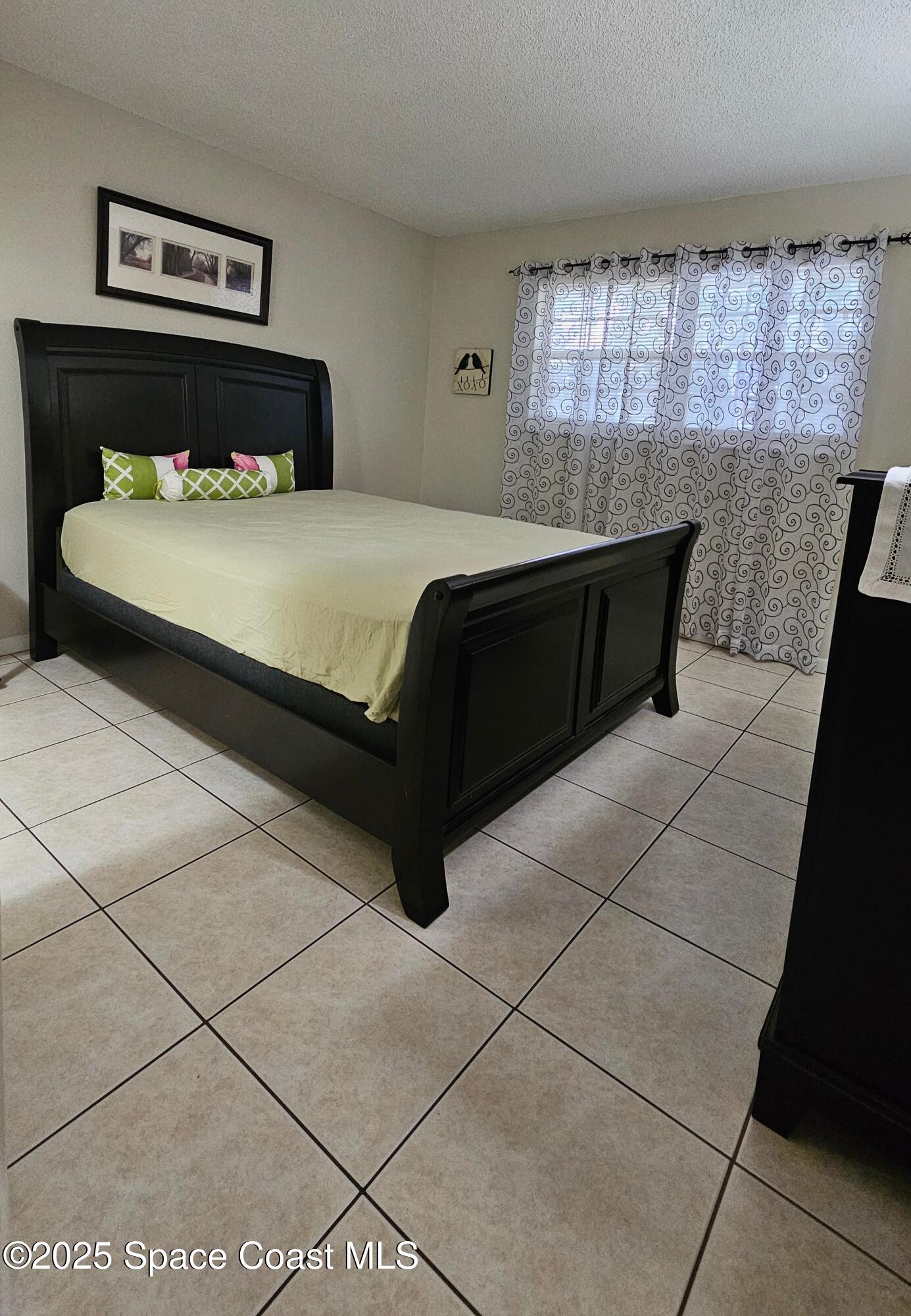 1641 Sunny Brook Lane, Unit C201 Palm Bay, FL 32905 - Photo 9 of 19 a bedroom with a bed and window