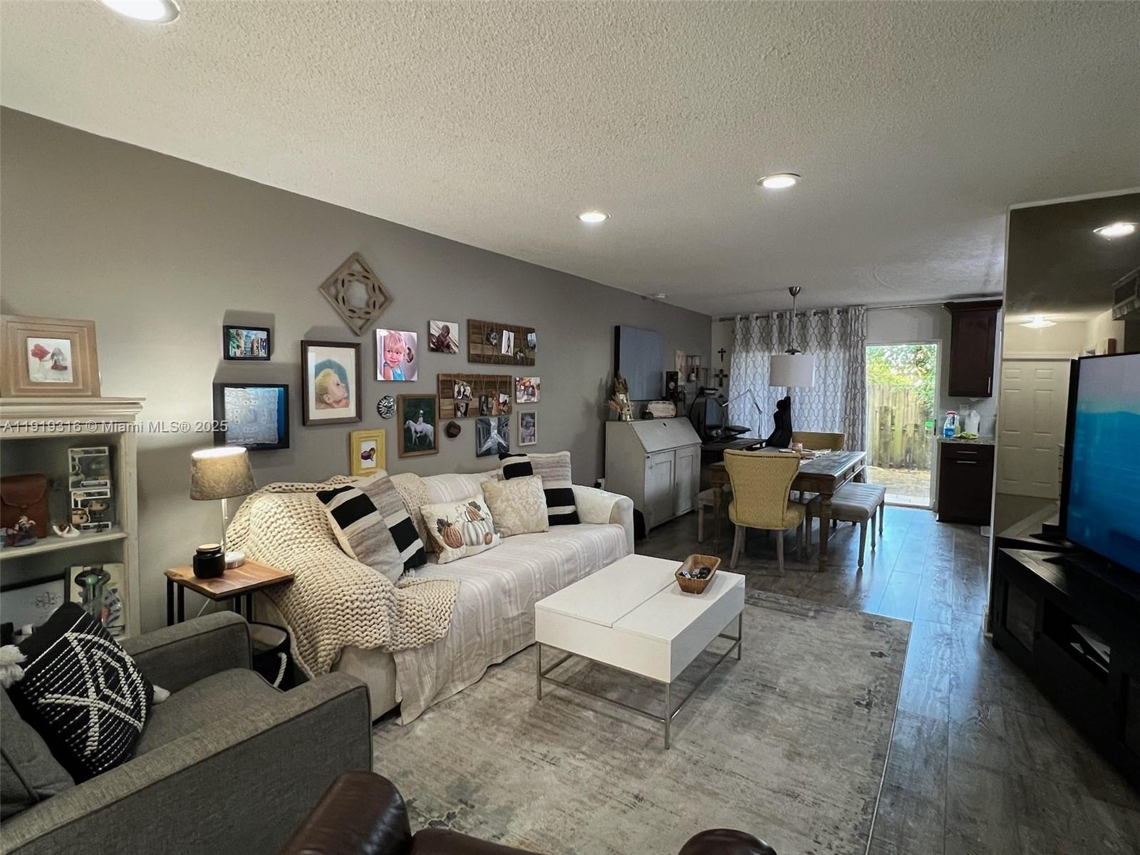 a living room with furniture a flat screen tv and a fireplace