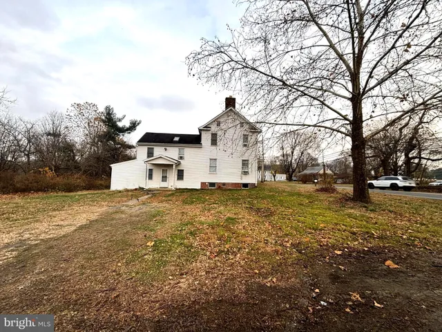 a white house that has a tree in front of it
