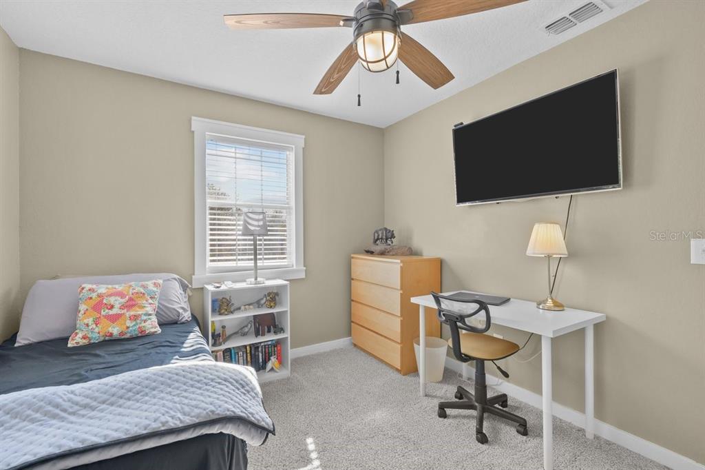 240 Whirlwind Loop Hawthorne, FL 32640 - Photo 18 of 39 a bedroom with a bed and a flat screen tv