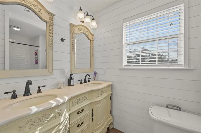 a bathroom with double vanity sink and a mirror