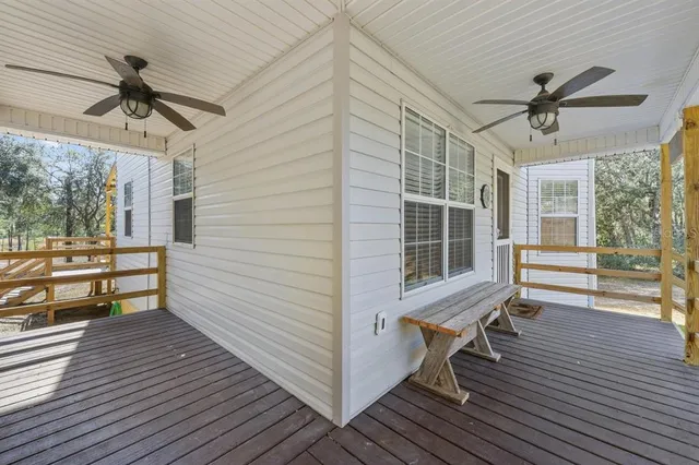 a view of a room with wooden floor and a ceiling fan
