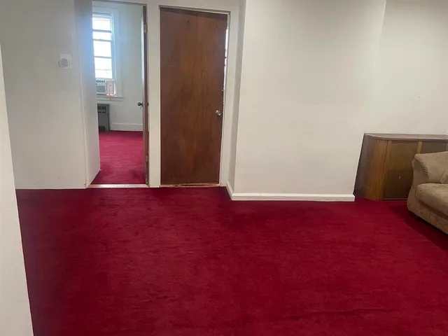 a bathroom with a granite countertop toilet a sink and a window