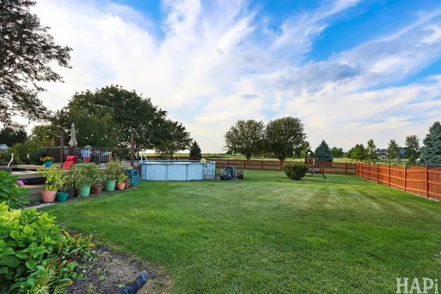 a view of yard with swimming pool and green space