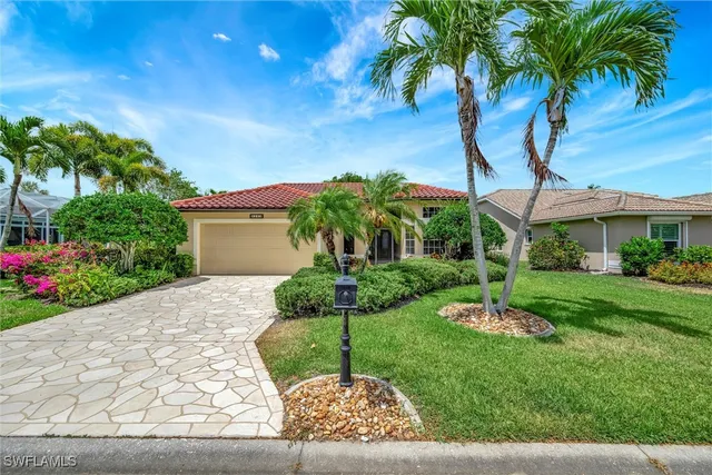 a view of a house with a yard and potted plants